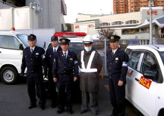 パトロール出発前の車両を背景に隊員と警官