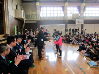 児童から地域関係者に鉢植えの贈呈