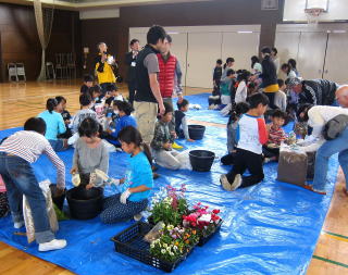 地域関係者の指導を受けながら、児童たちは鉢植え作業
