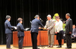 一般功労者代表で表彰状を受ける長谷川会長